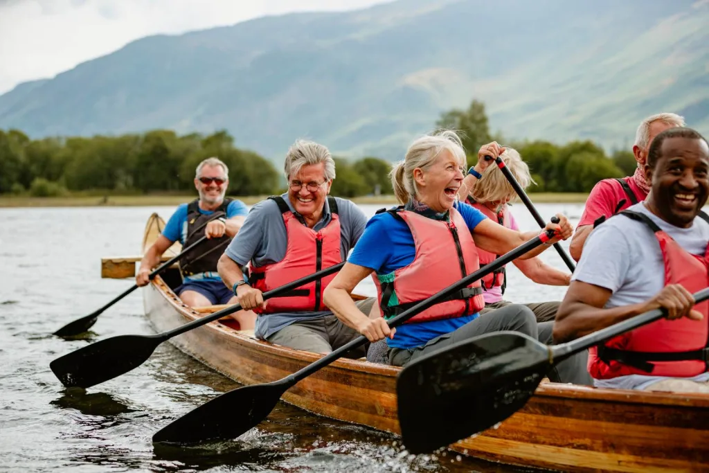 A senior group of mature senior friends enjoying rowing on the River Derwent